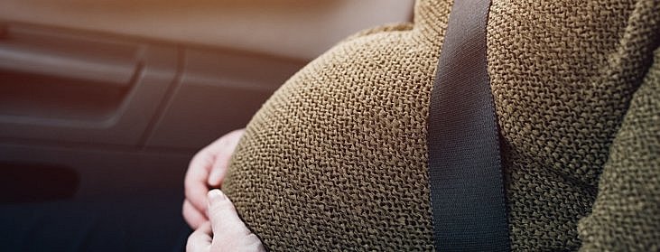 Pregnant woman with safety seat belt in the car